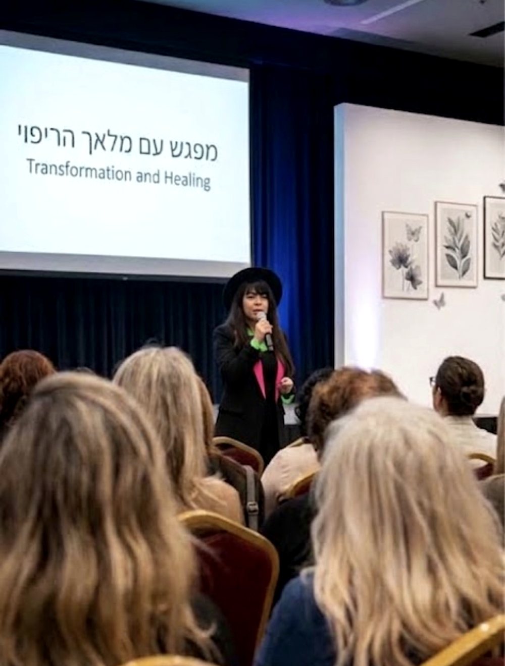 סימונה קוק מרצה בפני קהל במפגש 'מפגש עם מלאך הריפוי'
